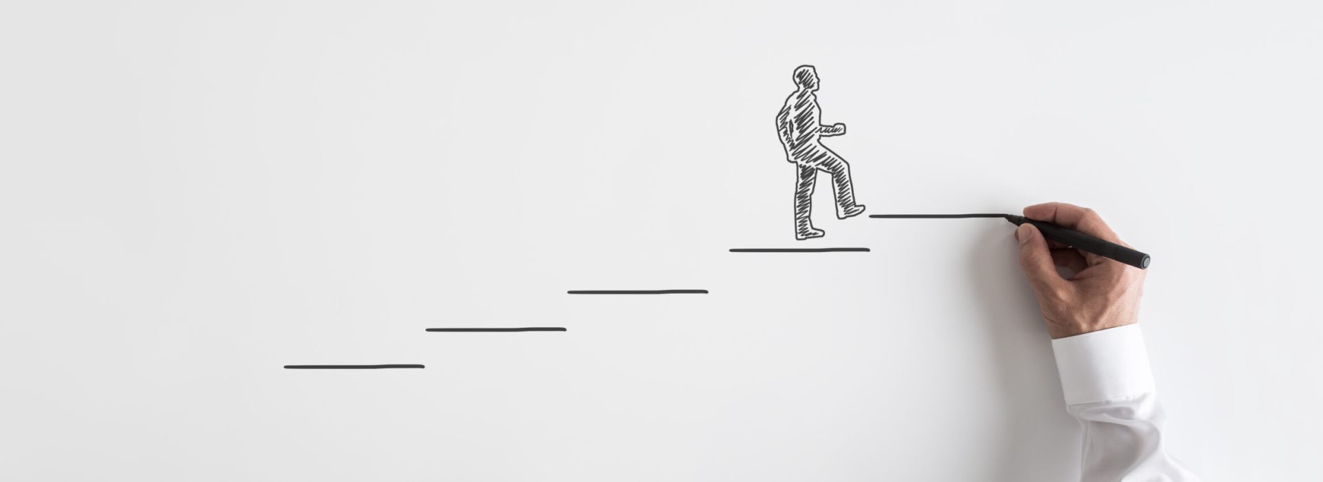 Wide view image of male hand drawing businessman walking up the stairs towards success over grey background.